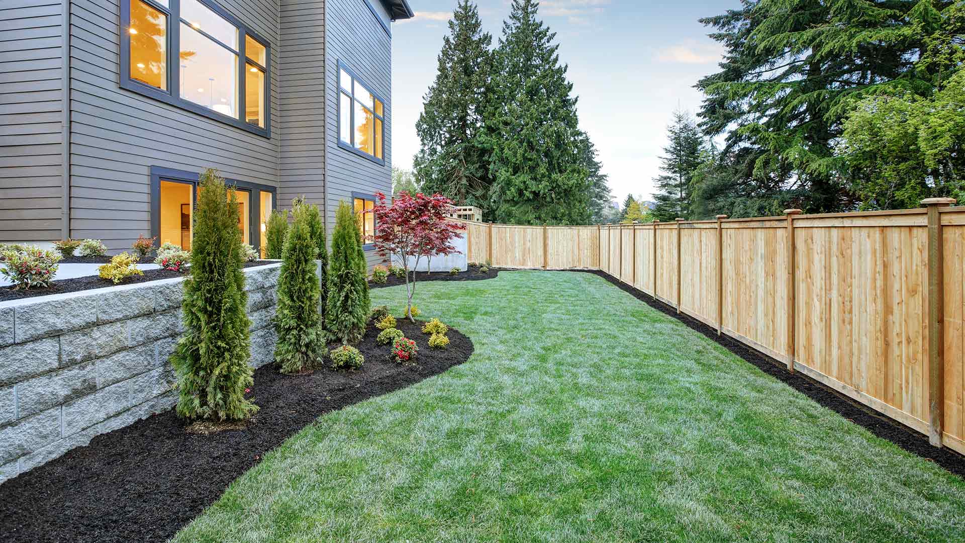 A stunning landscape bed and healthy green backyard lawn in Ashtabula, OH.