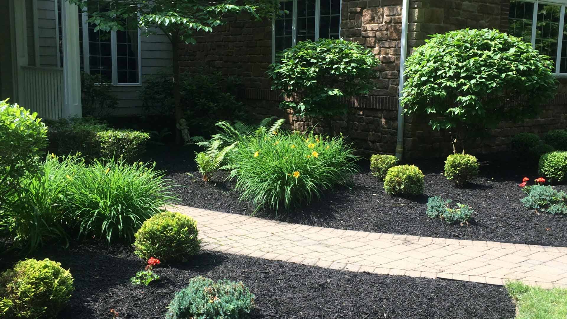 A home with a landscape bed maintained by professionals in Concord, OH.