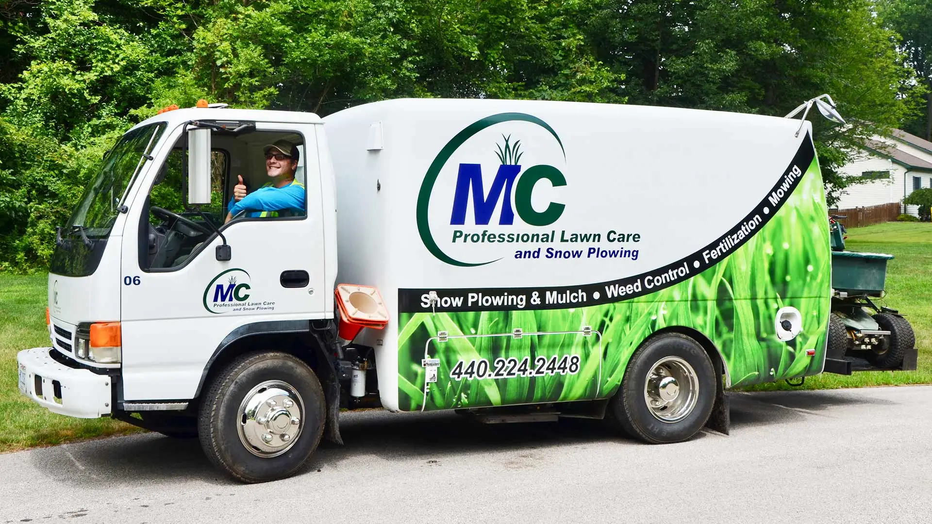 MC Professional Lawn Care and Snow Plowing worker giving thumbs up in service truck near Madison, OH.