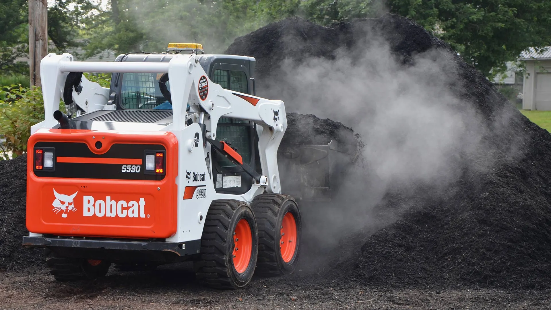 Rubber tire skid steer scooping warm mulch in Madison, OH.