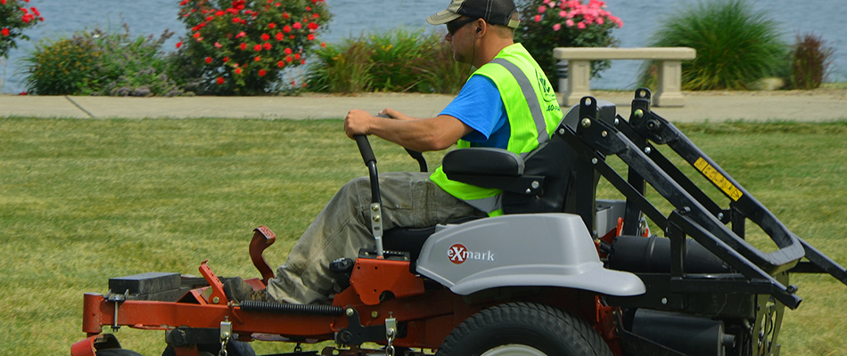 Expert lawn mower is cutting a beautiful lake-side property near Madison, OH.