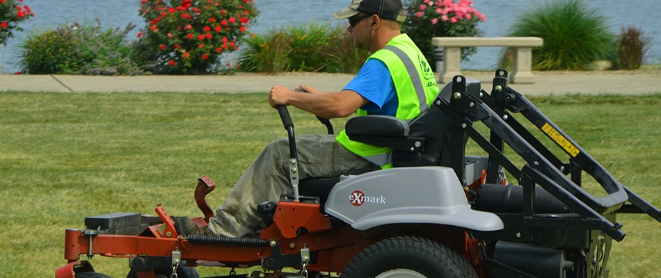 Expert lawn mower is cutting a beautiful lake-side property near Madison, OH.